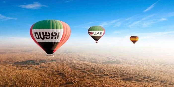 A hot air balloon soaring over the vast desert landscape of Dubai during a desert safari, offering stunning aerial views of the golden dunes