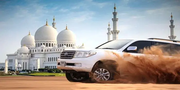 Tourists enjoying desert safari with camel ride and dune bashing in Abu Dhabi desert