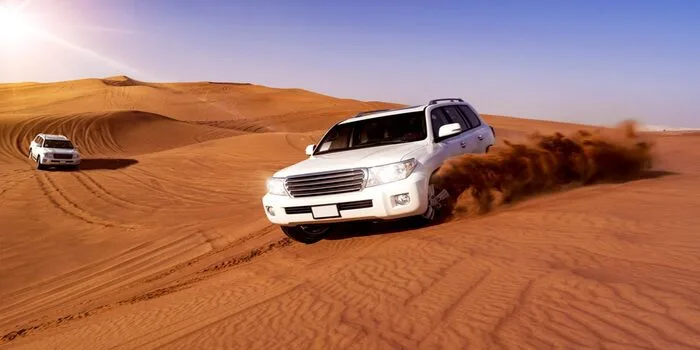 Desert safari in Dubai with dunes and tents, showing typical time spent for tourists