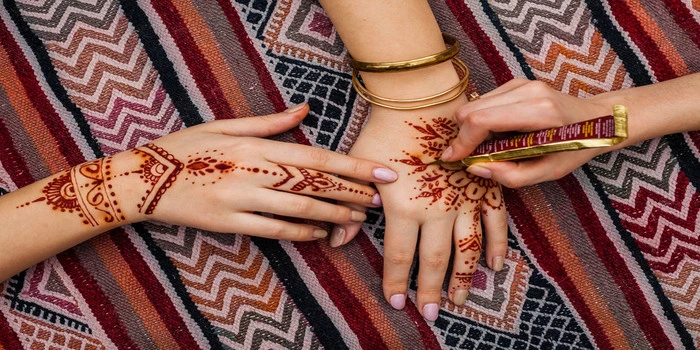 Women enjoying henna painting at a Dubai desert safari camp during sunset