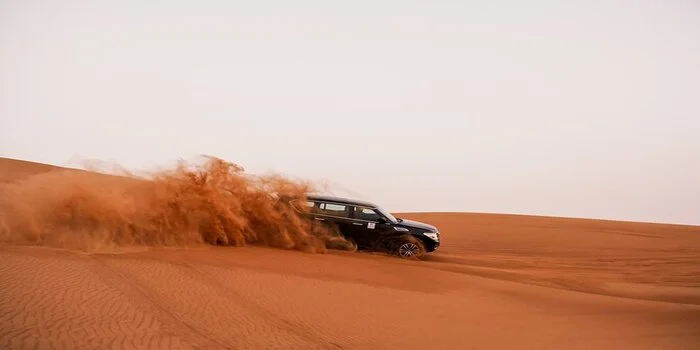 4x4 vehicle driving on sand dunes during desert safari in Dubai with proper dune driving technique