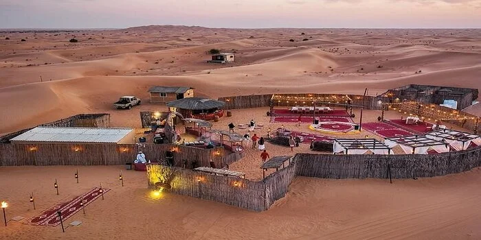 Multicultural travelers enjoying a desert safari experience in Dubai with traditional camp, camel rides, and cultural entertainment